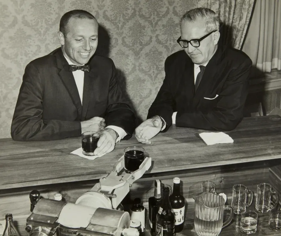 A robot serves drinks to Unimation co-founders Joseph Engelberger [left] and George Devol - Unimate